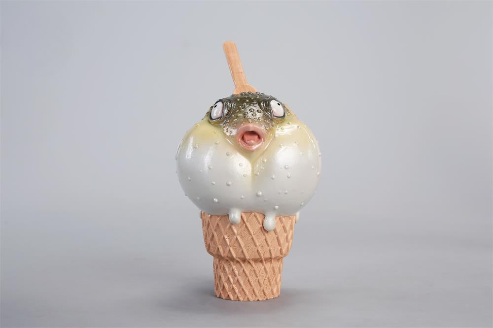 A highly detailed pufferfish ice cream figurine featuring a realistic fish with bulging eyes and textured scales, sitting on an intricately sculpted ice cream cone base. Made of premium resin, this collectible novelty item is perfect for unique decor lovers and marine life enthusiasts.