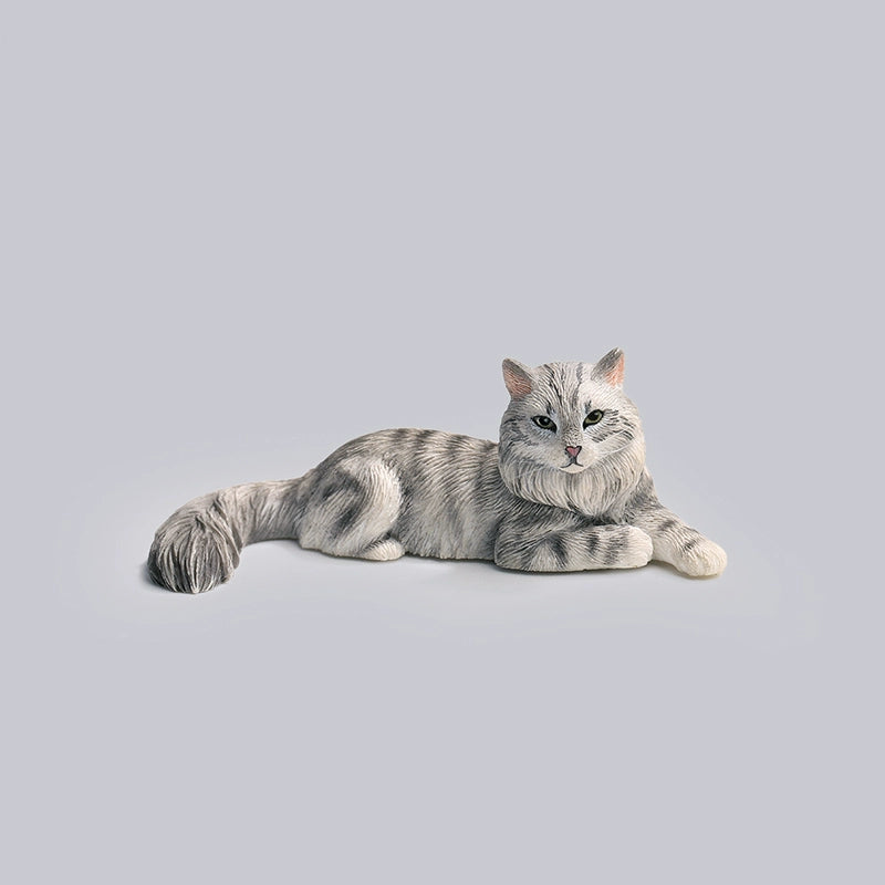 A detailed miniature model of a grey Maine Coon cat, lying in a relaxed position with intricate fur detailing and realistic coloring. This charming collectible captures the essence of a Maine Coon, perfect for cat lovers and model collectors. The cat model is part of a series featuring various poses and colors.