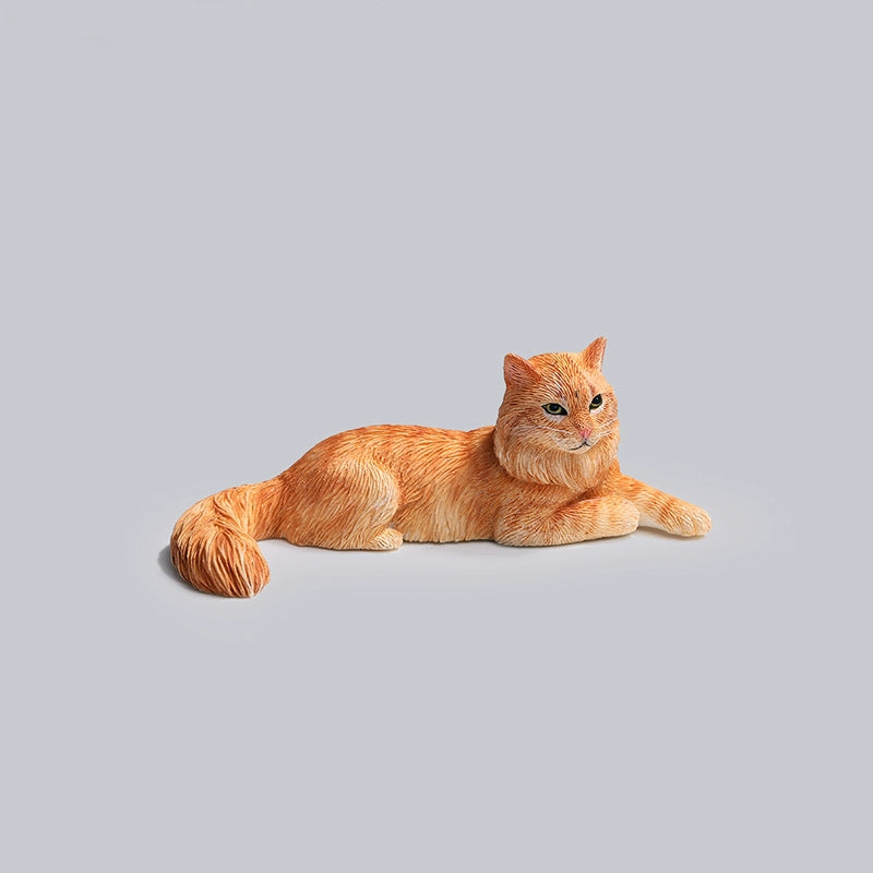 A detailed miniature model of a grey Maine Coon cat, lying in a relaxed position with intricate fur detailing and realistic coloring. This charming collectible captures the essence of a Maine Coon, perfect for cat lovers and model collectors. The cat model is part of a series featuring various poses and colors.