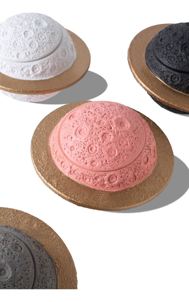 Discover the Pink Saturn-Shaped Pet Urn, a heartfelt memorial ashes holder crafted from durable Portland cement for North American pet owners. This whimsical planet-inspired design in soft pink, complete with a gold ring and textured craters, offers secure storage for up to 400ml of ashes from small pets. Measuring 16.5cm wide and 11cm tall, it weighs 1010g and fits perfectly on shelves or mantels, blending seamlessly into home decor. Ideal for cat or dog lovers seeking a unique tribute, it addresses grief 