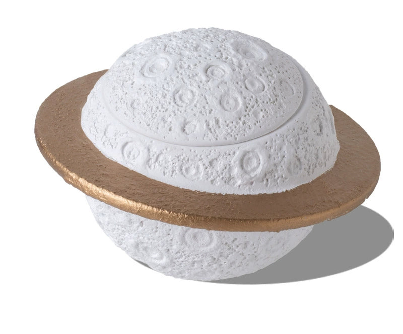 Discover the Pink Saturn-Shaped Pet Urn, a heartfelt memorial ashes holder crafted from durable Portland cement for North American pet owners. This whimsical planet-inspired design in soft pink, complete with a gold ring and textured craters, offers secure storage for up to 400ml of ashes from small pets. Measuring 16.5cm wide and 11cm tall, it weighs 1010g and fits perfectly on shelves or mantels, blending seamlessly into home decor. Ideal for cat or dog lovers seeking a unique tribute, it addresses grief 