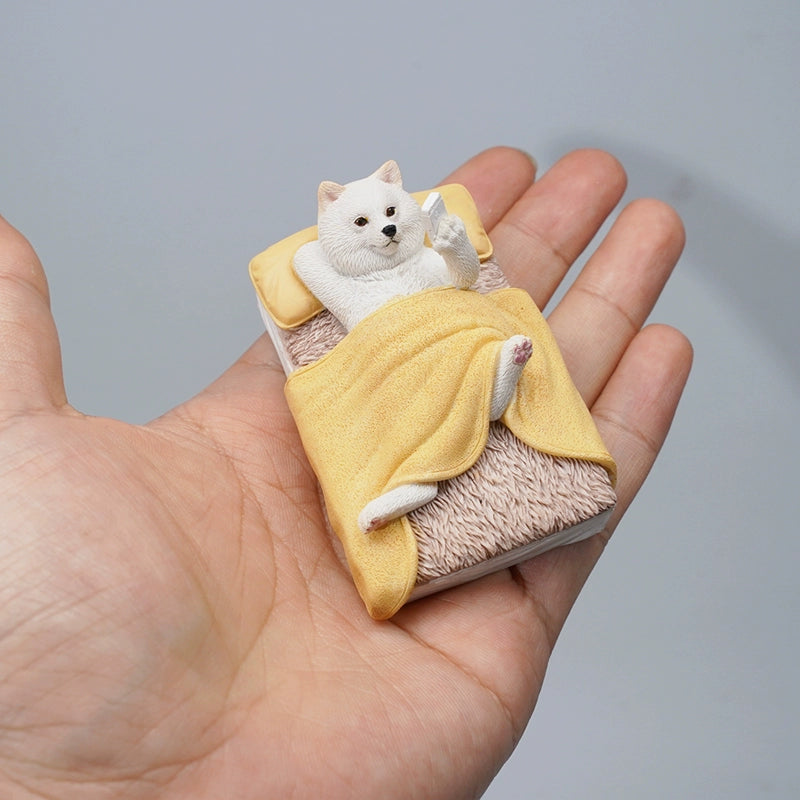 "A detailed figurine of a Shiba Inu dog lying in bed, wrapped in a yellow blanket and holding a smartphone, capturing the essence of relaxation and modern living."