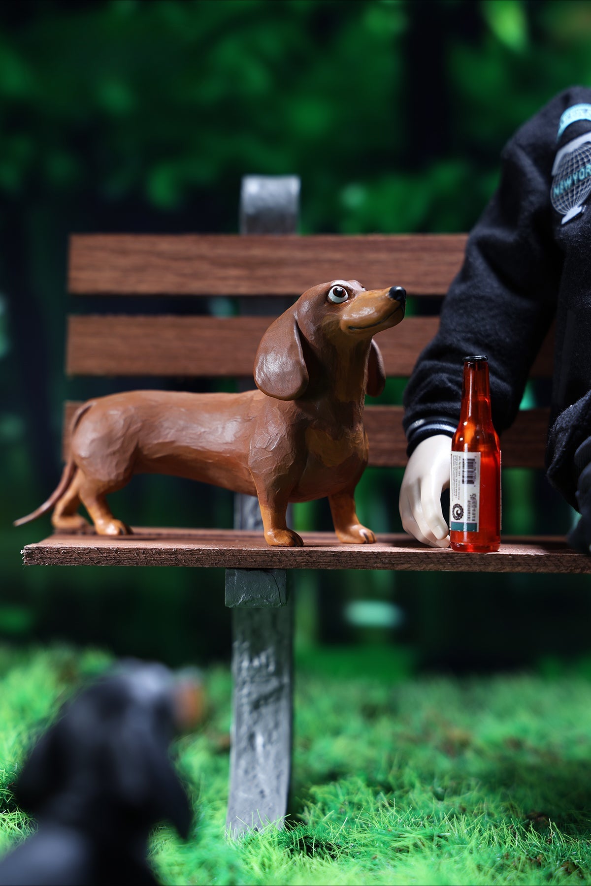 Two small clay Dachshund dog models, one black and one brown, captured in a realistic and lifelike manner. The models showcase detailed features, including expressive eyes and realistic fur textures. Perfect for collectors and dog enthusiasts.