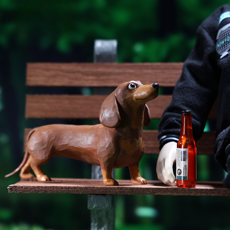 Two small clay Dachshund dog models, one black and one brown, captured in a realistic and lifelike manner. The models showcase detailed features, including expressive eyes and realistic fur textures. Perfect for collectors and dog enthusiasts.