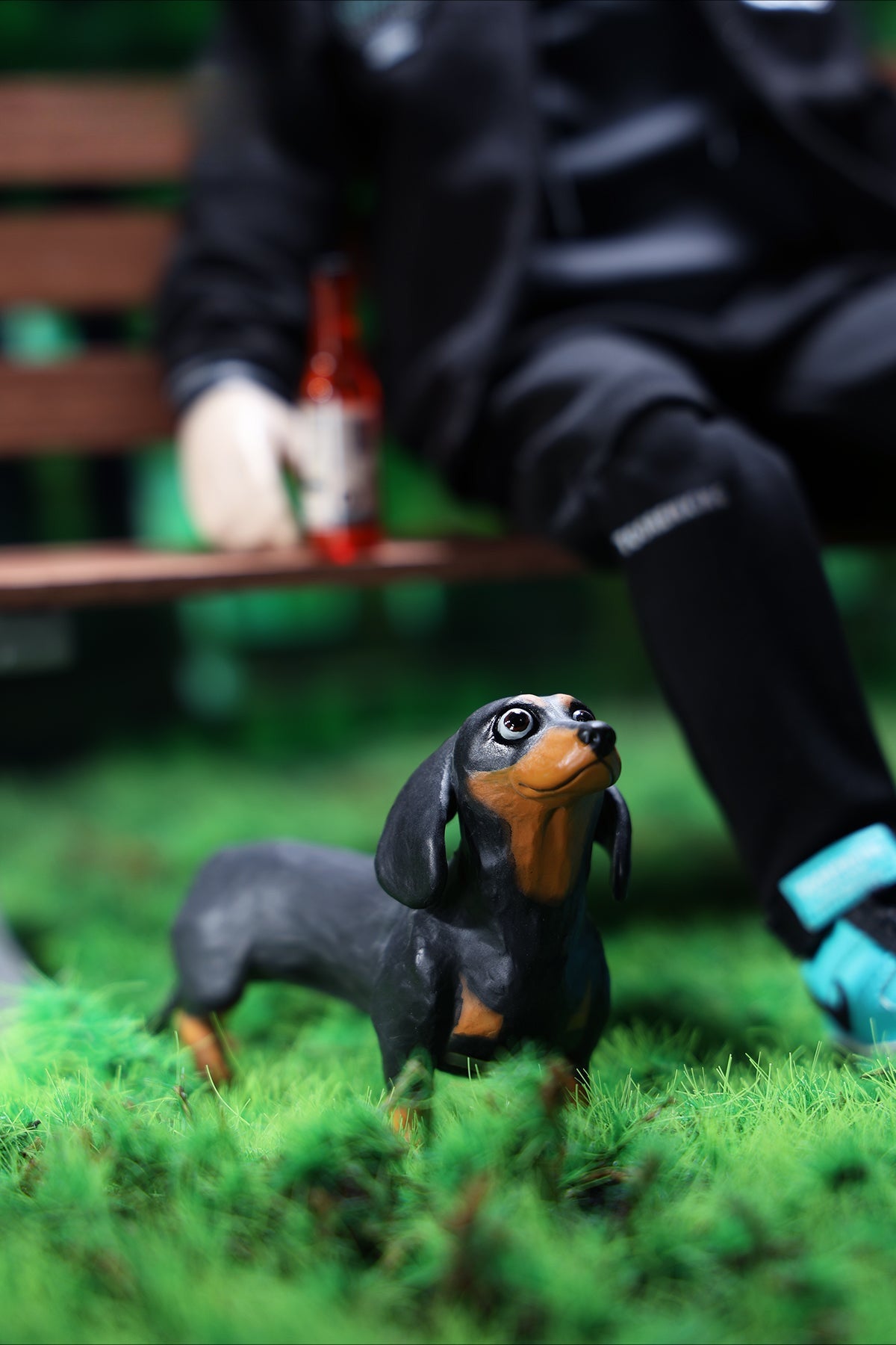 Two small clay Dachshund dog models, one black and one brown, captured in a realistic and lifelike manner. The models showcase detailed features, including expressive eyes and realistic fur textures. Perfect for collectors and dog enthusiasts.