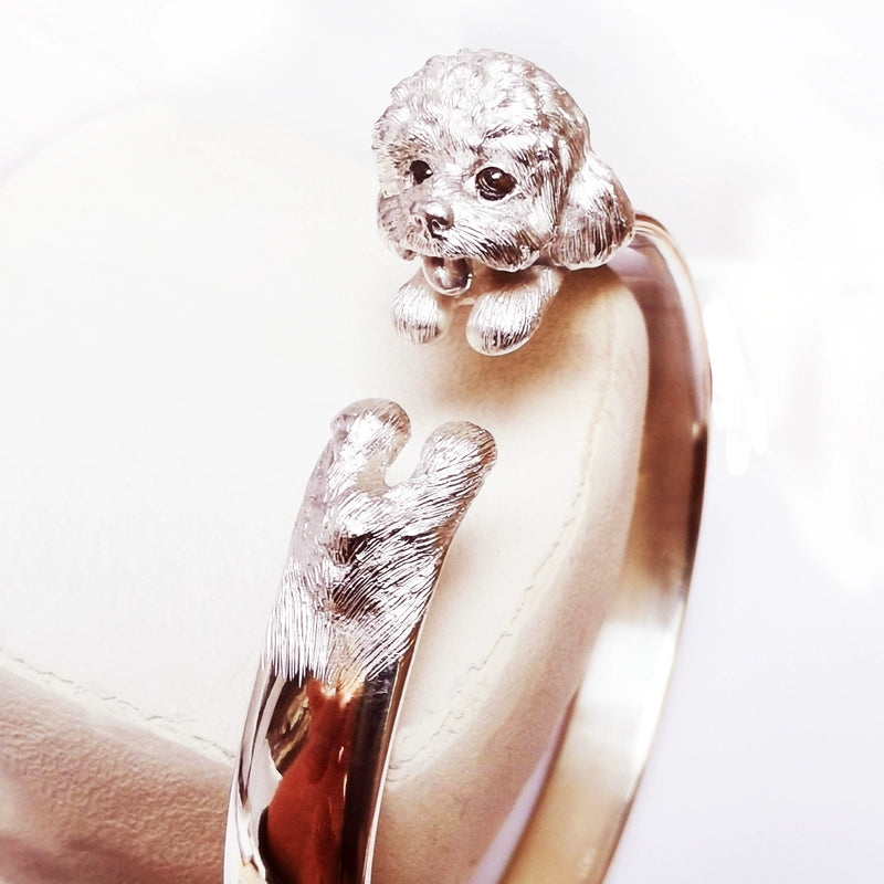 Sterling Silver Teddy Ring featuring a lifelike hand-carved puppy design, available in silver or antique black finish. The ring showcases intricate detailing with black obsidian eyes, making it a unique keepsake for pet lovers.