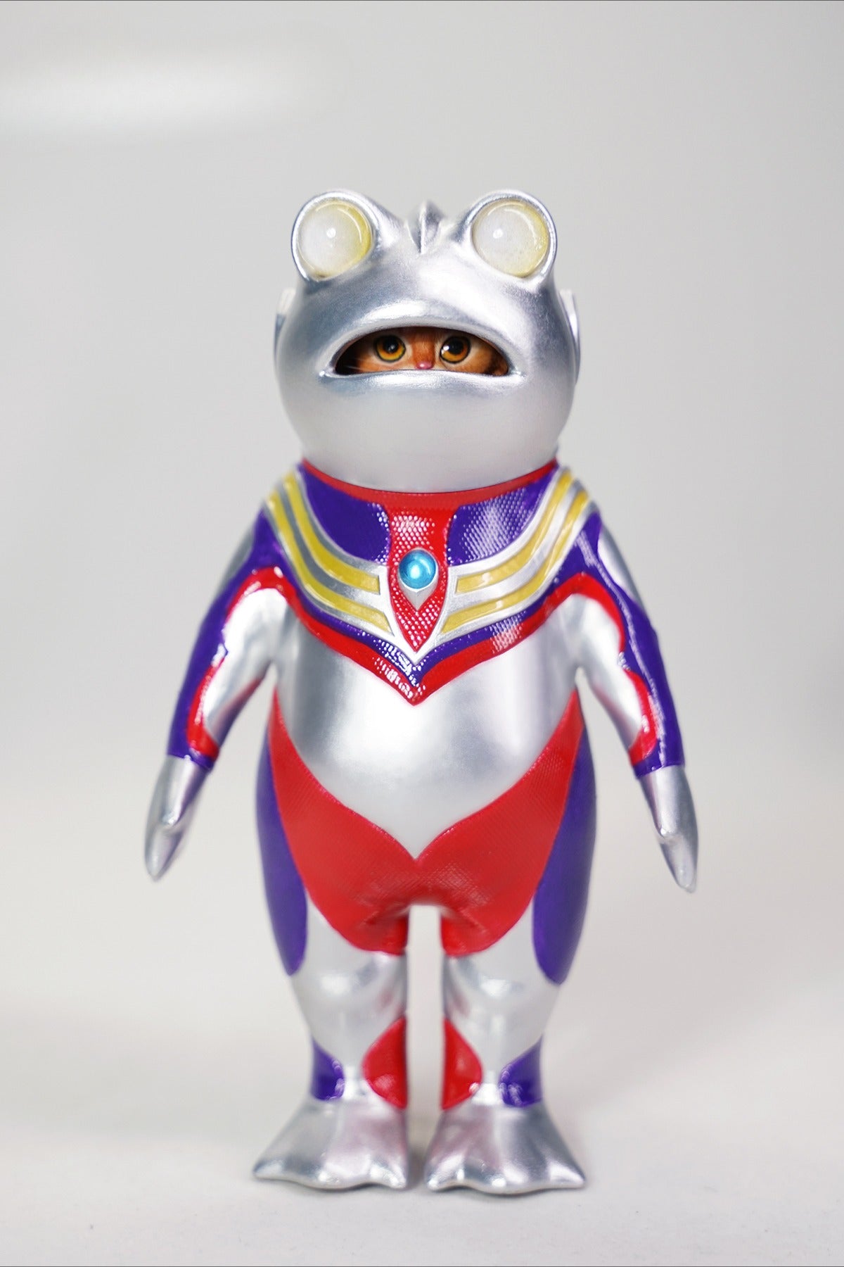This Ultrafrog action figure features a frog body with a removable cat head sculpture, made of durable vinyl. The figure measures 9 x 5 x 16 cm and includes a magnetic headpiece that can rotate, making it a fun and customizable collectible for fans of unique hybrid figures, superheroes, and creative designs.
