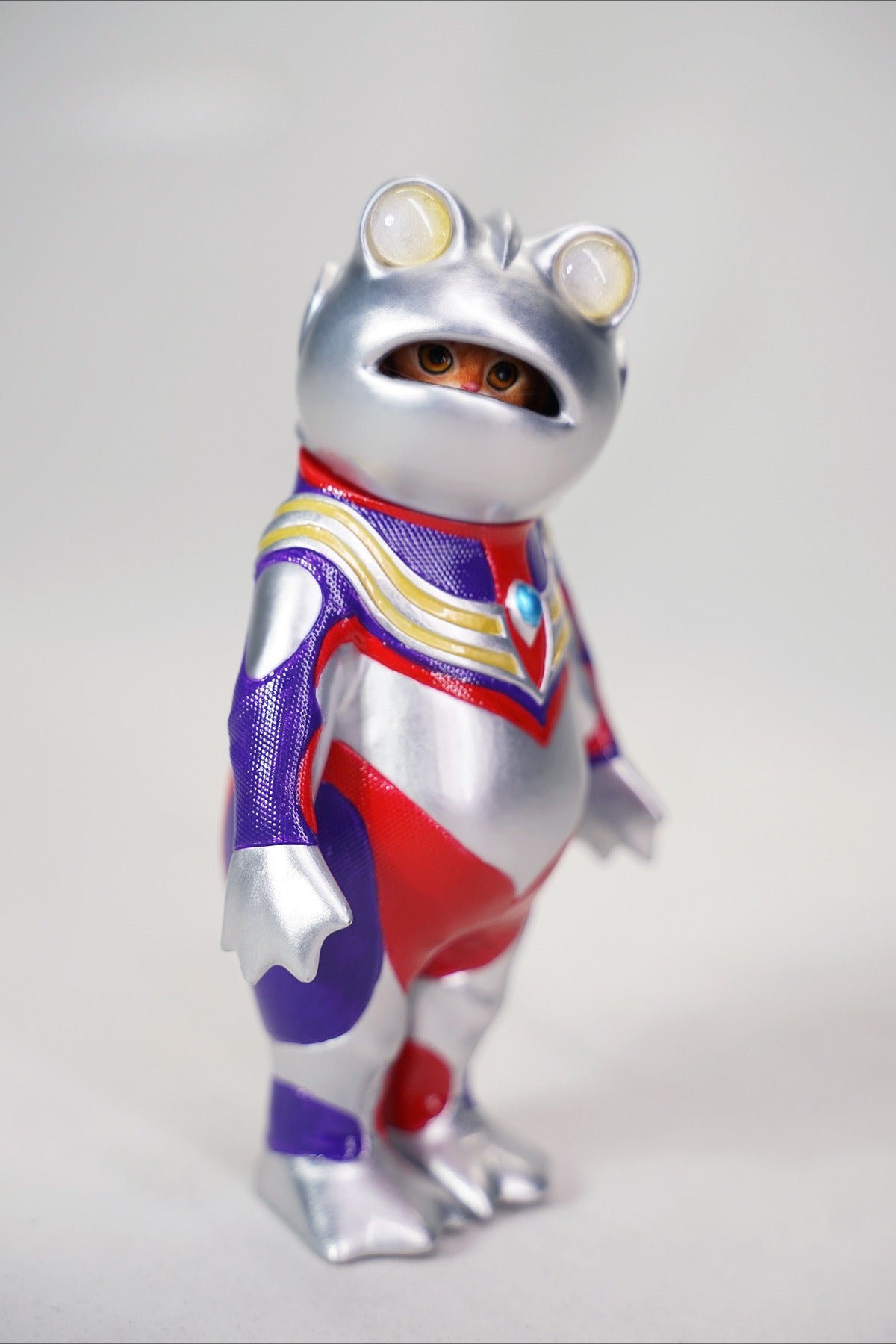 This Ultrafrog action figure features a frog body with a removable cat head sculpture, made of durable vinyl. The figure measures 9 x 5 x 16 cm and includes a magnetic headpiece that can rotate, making it a fun and customizable collectible for fans of unique hybrid figures, superheroes, and creative designs.