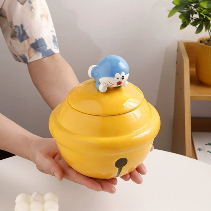 Yellow ceramic Doraemon pet cremation urn with a glossy finish, featuring a round shape and a cute Doraemon figure on top, ideal for North American pet owners. This handcrafted urn provides secure ashes storage, perfect for home memorial display on mantels or shelves, with a vibrant yellow hue and playful design.