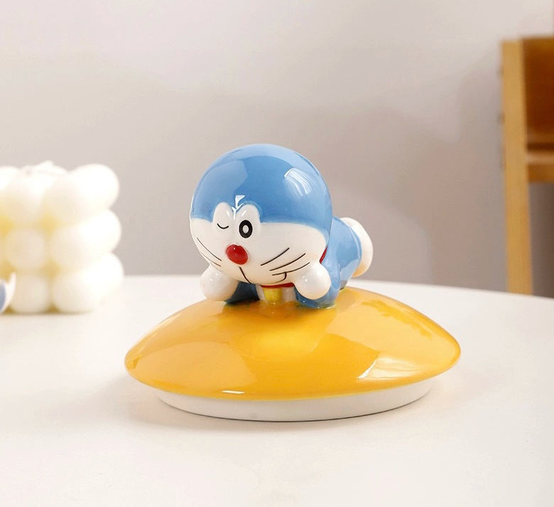 Yellow ceramic Doraemon pet cremation urn with a glossy finish, featuring a round shape and a cute Doraemon figure on top, ideal for North American pet owners. This handcrafted urn provides secure ashes storage, perfect for home memorial display on mantels or shelves, with a vibrant yellow hue and playful design.