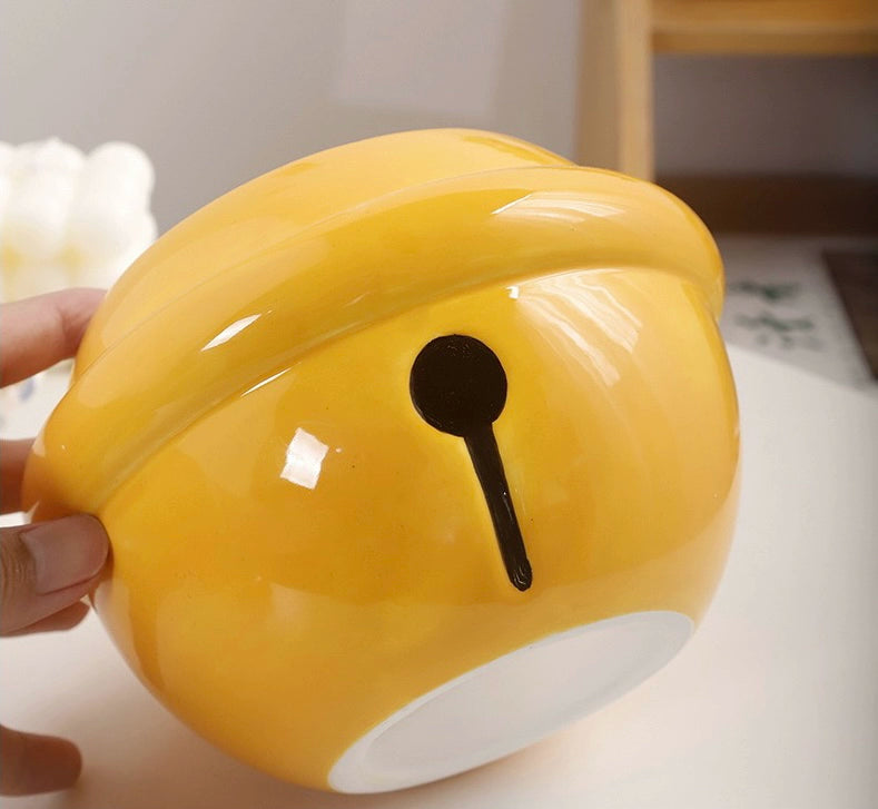 Yellow ceramic Doraemon pet cremation urn with a glossy finish, featuring a round shape and a cute Doraemon figure on top, ideal for North American pet owners. This handcrafted urn provides secure ashes storage, perfect for home memorial display on mantels or shelves, with a vibrant yellow hue and playful design.