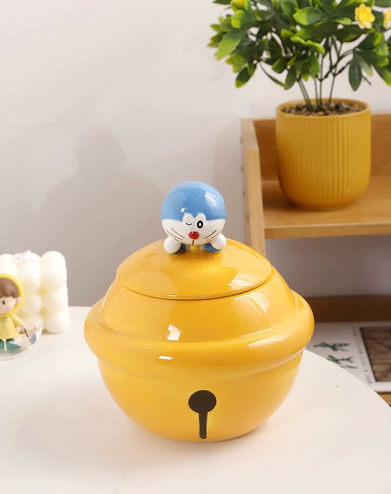 Yellow ceramic Doraemon pet cremation urn with a glossy finish, featuring a round shape and a cute Doraemon figure on top, ideal for North American pet owners. This handcrafted urn provides secure ashes storage, perfect for home memorial display on mantels or shelves, with a vibrant yellow hue and playful design.