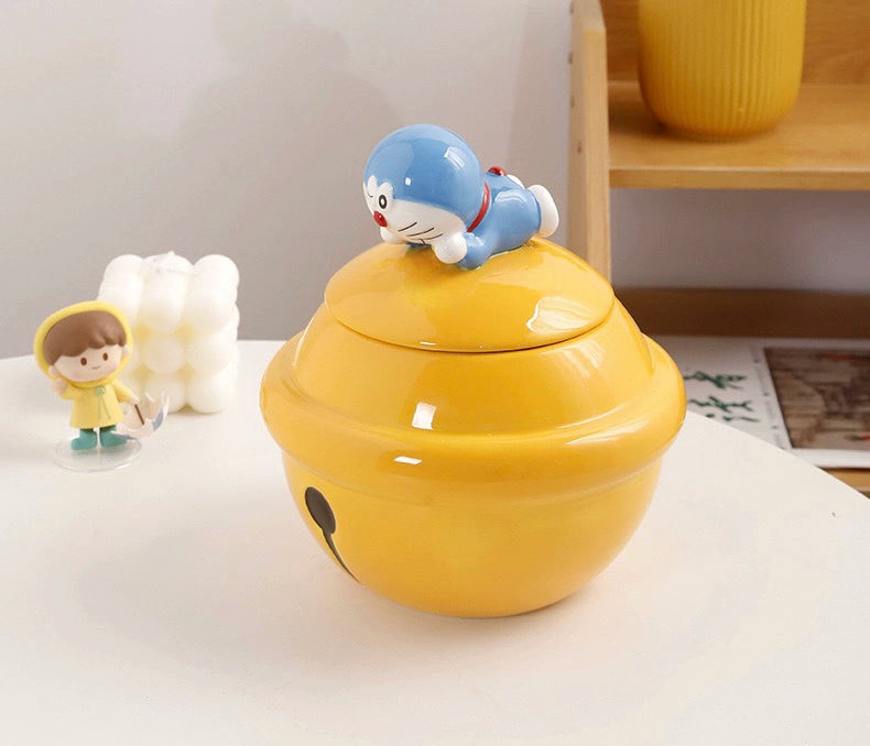 Yellow ceramic Doraemon pet cremation urn with a glossy finish, featuring a round shape and a cute Doraemon figure on top, ideal for North American pet owners. This handcrafted urn provides secure ashes storage, perfect for home memorial display on mantels or shelves, with a vibrant yellow hue and playful design.