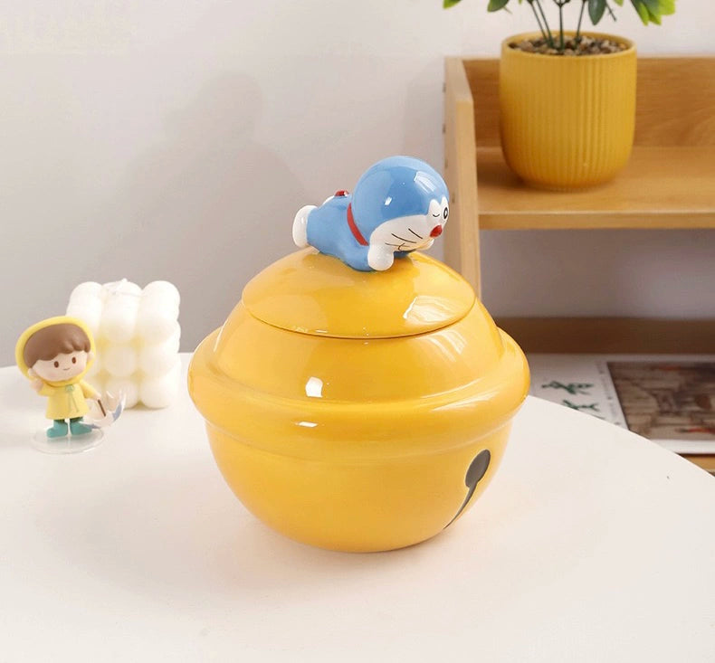 Yellow ceramic Doraemon pet cremation urn with a glossy finish, featuring a round shape and a cute Doraemon figure on top, ideal for North American pet owners. This handcrafted urn provides secure ashes storage, perfect for home memorial display on mantels or shelves, with a vibrant yellow hue and playful design.
